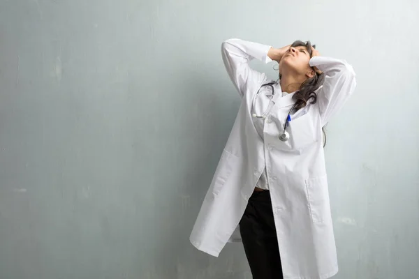 Young indian doctor woman against wall frustrated and desperate