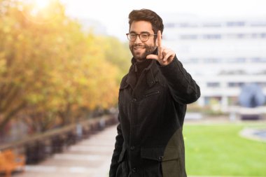 seri bir jest yapan genç erkek