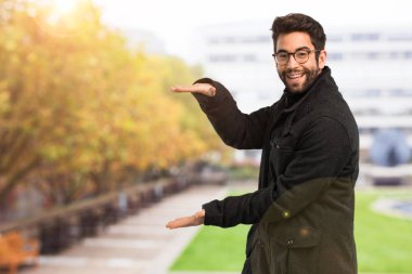 Genç adam bir şey tutuyor.