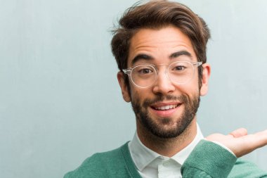 Elleriyle bir şey tutan, bir ürün, gülümseyen ve neşeli gösterilen, hayali bir nesne sunan genç yakışıklı girişimci adam yüz portre