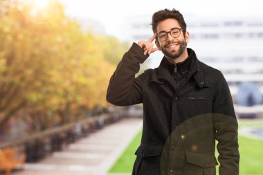 Genç adam bir şey tutuyor.