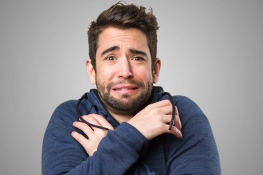 Genç adam sahip soğuk gri arka plan üzerinde