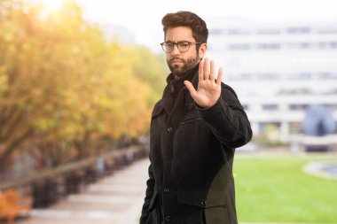 Dur bir jest yapan genç erkek