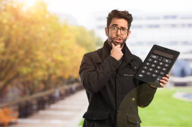 Genç adam bir hesap makinesi holding