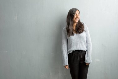 Kendinden emin ve başarılı genç Hintli kadın rahat ve neşeli, gülen ve having fun, grunge duvara hissediyor