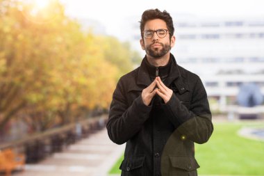 Genç adam Tanrı 'ya dua ediyor.