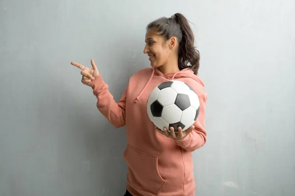 Joven Mujer India Deportiva Contra Una Pared Apuntando Hacia Lado — Foto de Stock