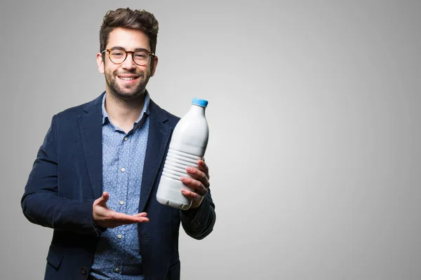 Молодой Человек Бутылкой Молока Сером Фоне — стоковое фото
