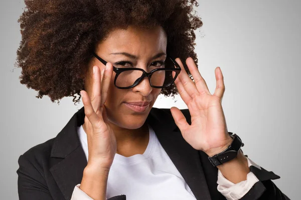Negro Mujer Negocios Poniéndose Sus Gafas Sobre Fondo Gris — Foto de Stock