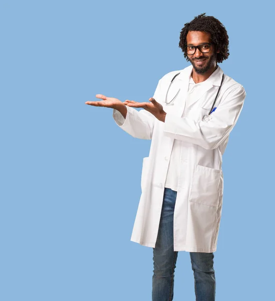 Médico Afro Americano Bonito Segurando Algo Com Mãos Mostrando Produto — Fotografia de Stock