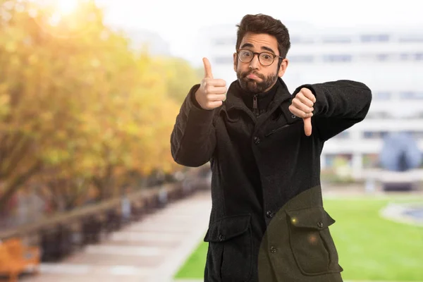 Young Man Doubting Two Things — Stock Photo, Image