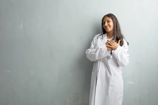 Young indian doctor woman against a wall frustrated and desperate, angry and sad with hands on head