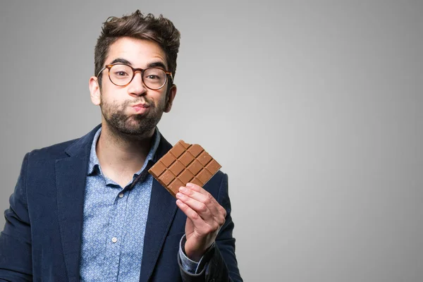 Mladý Muž Jíst Čokolády Šedém Pozadí — Stock fotografie