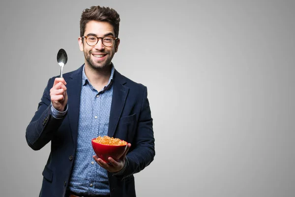 Mladý Muž Který Držel Miskou Corn Flakes Šedém Pozadí — Stock fotografie