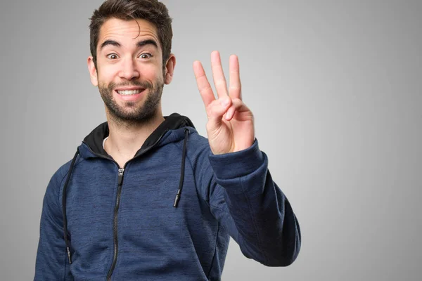 Joven Haciendo Gesto Número Tres Sobre Fondo Gris —  Fotos de Stock