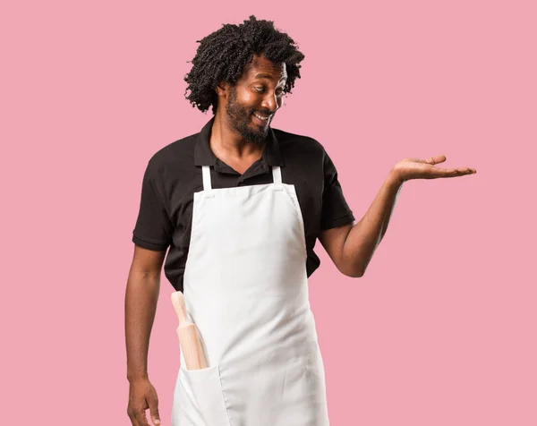 Hezký Afroamerické Baker Drží Něco Rukama Ukazující Produkt Usměvavá Veselá — Stock fotografie