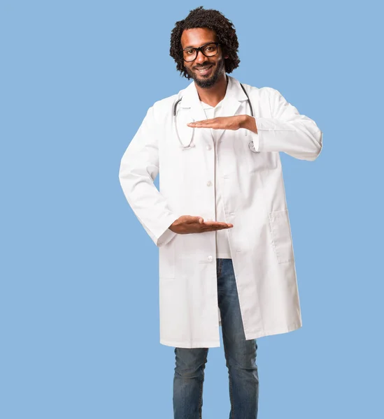 Médico Afro Americano Bonito Segurando Algo Com Mãos Mostrando Produto — Fotografia de Stock