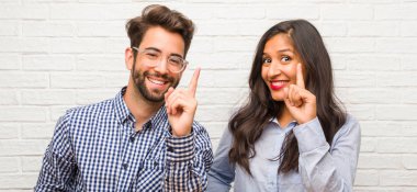 Genç Hintli kadın ve beyaz adam çift gösterilen bir numaralı simgesi sayma, matematik, kendinden emin ve neşeli kavramı