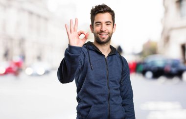 Genç adam arka plan bulanık iyi jest yapıyor