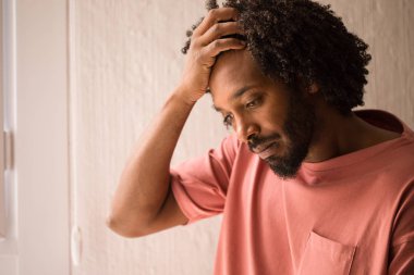 Afrika delikanlı yüz closeup, şok ve ciddi bir pencere yakınında.