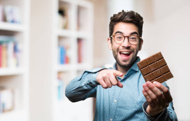 açık işaret ve çikolata tutan genç adam arka plan bulanık