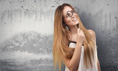 grunge gri arka plan üzerinde parti gözlük kullanan genç ve güzel kadın