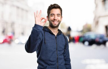 Genç adam arka plan bulanık iyi jest yapıyor