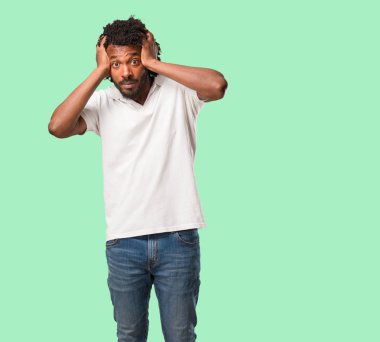 Yakışıklı Afrikalı-Amerikalı sinirli ve umutsuz, kızgın ve üzgün ile ellerinizi başınızın koyun