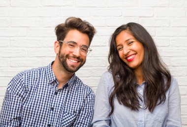 Adam genç Hintli kadın ve beyaz çift neşeli ve kocaman bir gülümseme, kendine güvenen, dostu ile ve samimi, ifade pozitifliği ve başarı