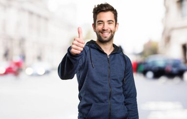 Genç adam arka plan bulanık iyi jest yapıyor