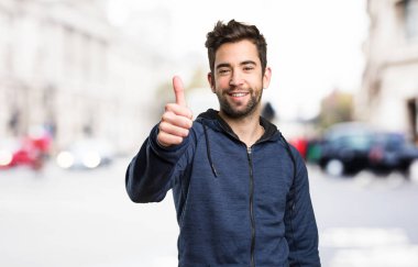 Genç adam arka plan bulanık iyi jest yapıyor