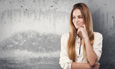 Genç ve güzel kadın grunge gri arka plan üzerinde düşünme