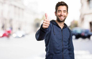 Genç adam arka plan bulanık iyi jest yapıyor