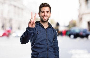 İki numaralı jest yapıyor genç adam arka plan bulanık