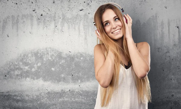 Frau Hört Musik Über Kopfhörer Auf Grauem Grunge Hintergrund — Stockfoto