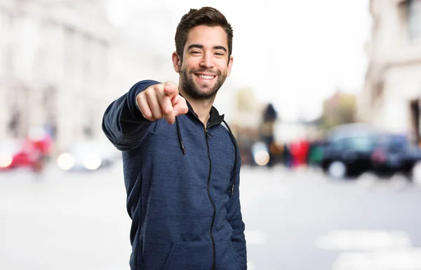 Junger Mann Zeigt Auf Verschwommenen Hintergrund — Stockfoto