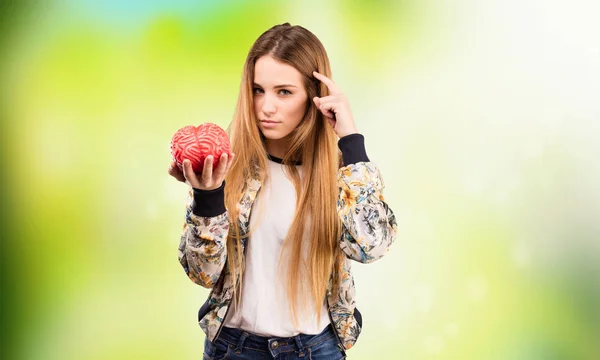 Mooie Jonge Vrouw Met Een Hersenen Object Groene Achtergrond Wazig — Stockfoto