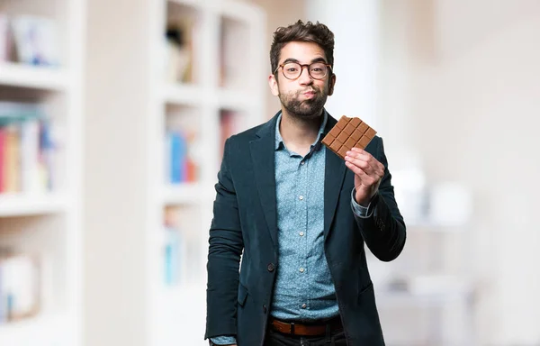 Joven Comiendo Una Barra Chocolate Sobre Fondo Borroso — Foto de Stock