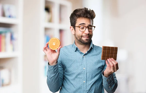 Mladý Muž Který Držel Pomeranče Čokolády Rozostřeného Pozadí — Stock fotografie