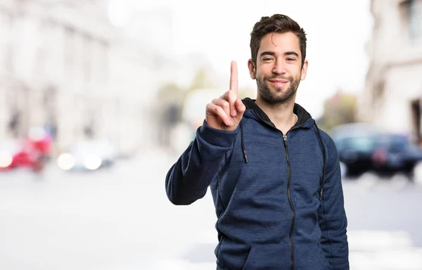 Joven Haciendo Gesto Número Uno Sobre Fondo Borroso — Foto de Stock