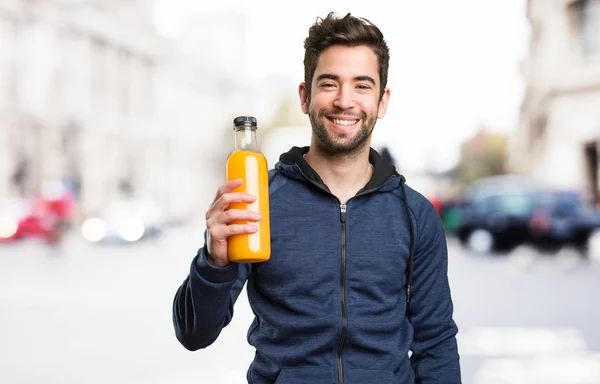 Ung Man Håller Flaska Juice Suddig Bakgrund — Stockfoto