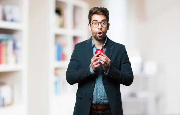 Joven Sorprendido Sosteniendo Una Manzana Sobre Fondo Borroso — Foto de Stock