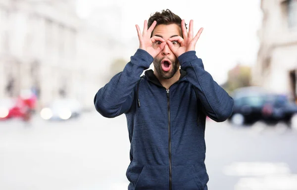 Έκπληκτος Νεαρός Άνδρας Κάνει Γυαλιά Χειρονομία Θολή Φόντο — Φωτογραφία Αρχείου