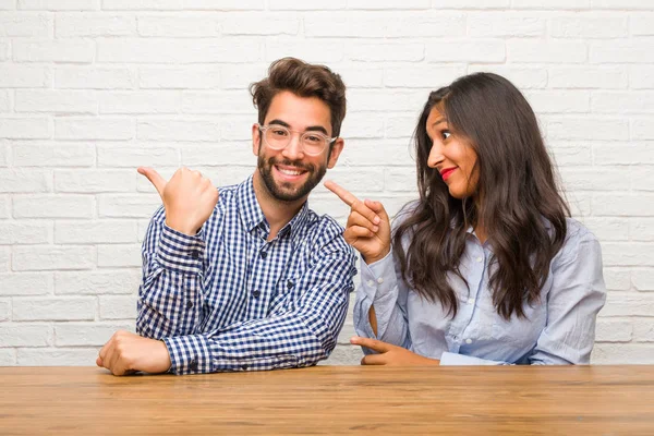 Jonge Indiase Vrouw Kaukasische Man Paar Wijst Naar Kant Glimlachend — Stockfoto