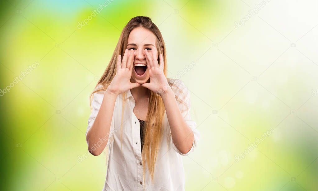 pretty young woman shouting on blurred green background