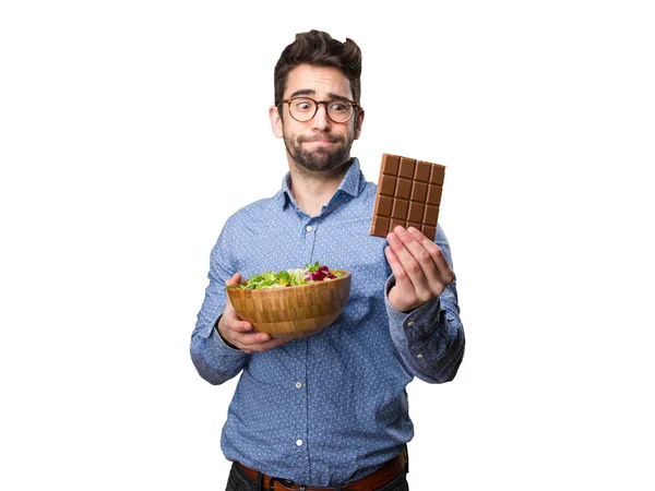 Joven Sosteniendo Una Ensalada Una Barra Chocolate Aislada Sobre Fondo — Foto de Stock