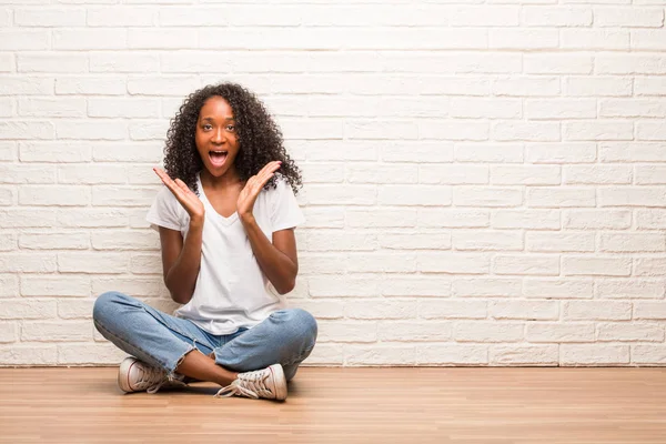 Young Black Woman Sitting Wooden Floor Surprised Shocked Brick Wall — Stock Photo, Image