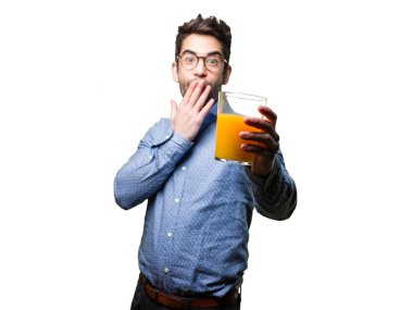 bir bardak beyaz arka plan üzerinde izole meyve suyu tutan şaşırmış genç adam