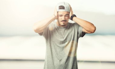 Eller, kızgın ve bazı ses işitme yorgun kulaklarıyla kapsayan genç rapçi adam