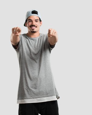 Genç rapçi adam neşeli ve gülümseyerek önüne işaret